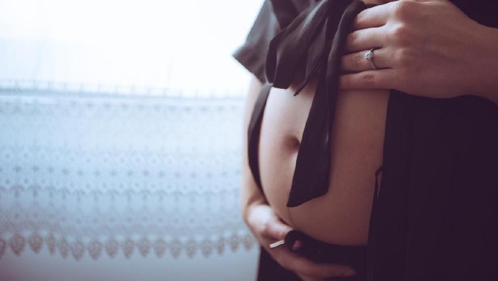 pregnant woman making heart shape with hands. first month of the pregnancy.