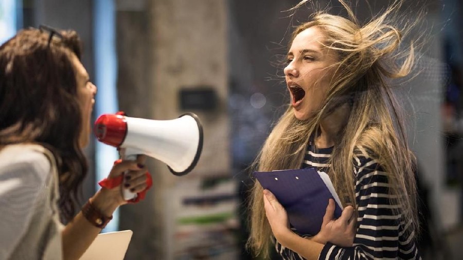 Rude female leader yelling at her coworker through megaphone.