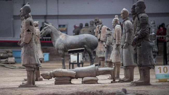 Menurut pernyataan pihak berwenang setempat, aksi turis itu mengakibatkan kerusakan pada dua patung prajurit tanah liat kuno di situs warisan dunia UNESCO.
