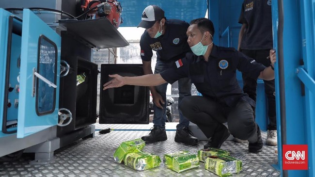 Petugas Badan Narkotika Nasional (BNN) melakukan pemusnahan barang bukti narkotika dengan mesin incinerators di kantor BNN Cawang, Jakarta Timur (8/11). Jumlah barang bukti yang dimusnahkan antara lain shabu seberat 57,4kg dan ekstasi sebanyak 66.490. ( CNN Indonesia/ Hesti Rika)