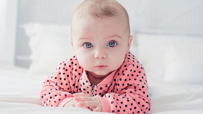 Cute baby girl on the white bed