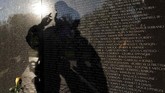 Refleksi seorang pengunjung di tembok Monumen Veteran Vietnam, berisi lebih dari 58 ribu nama tentara Amerika Serikat saat Hari Veteran di Washington, AS. (Reuters/Yuri Gripas)