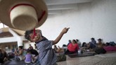 Seorang anak imigran melempar topi di sebuah kamp di Pijijiapan, Meksiko. Ia adalah salah satu yang ikut dalam karavan dari Amerika Tengah yang ingin menuju Amerika Serikat. (Reuters/Ueslei Marcelino)