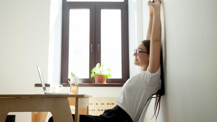 Young cheerful businesswoman listening music in headphones at office.