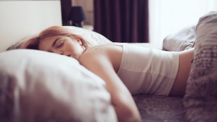 Young woman sleeping in bed. Space for copy.
