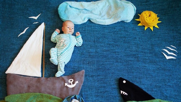 Little baby boy, playing wtih little boat and little fish at home, having sailor hat