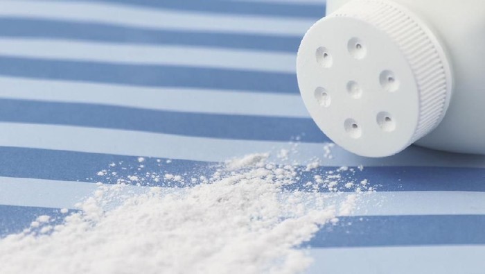 Spilled baby scented powder on striped background with short depth of field