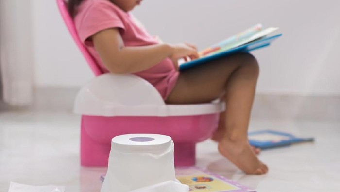 smart kids. learning how to read. toilet training. child with toilet paper, potty, and books.