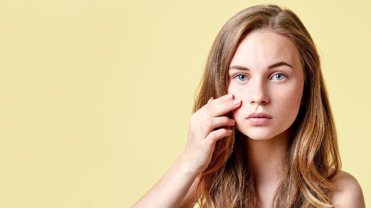 Eyes Woman freckle happy young beautiful portrait with healthy skin half. Studio shot.