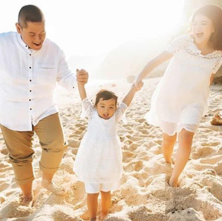 <p>Wah, ada yang asyik main sama ayah dan bundanya nih di pantai. (Foto: Instagram @ taniaputri1707)  </p>