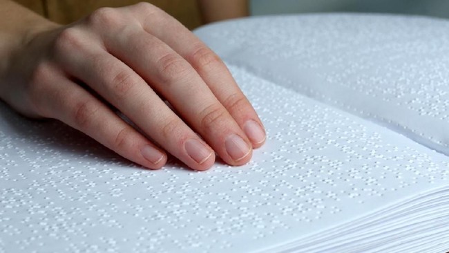 Blind woman read book written in BrailleBook written in braille alphabet for blind people