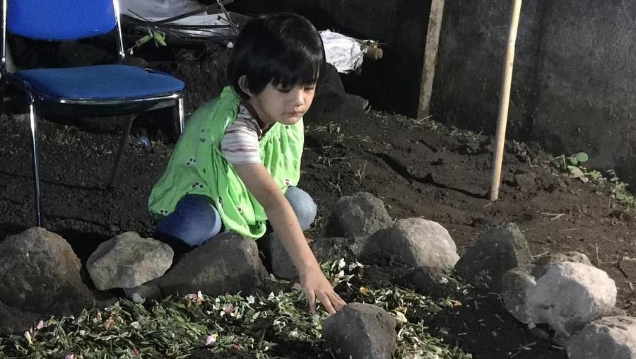 Anak sulung Herman Seventeen, Hafuza Dhamiri, menahan tangisnya saat mendatangi makam sang ayah.