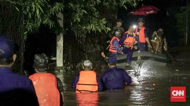 Sibuk membantu sesama, petugas yang menolong warga menyelamatkan diri dari banjir tak sadar jika tahun telah berganti dari 2018 ke 2019. 