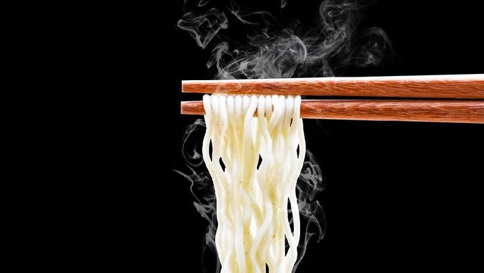 Instant noodle and spicy seasoning in white bowl with chopstick