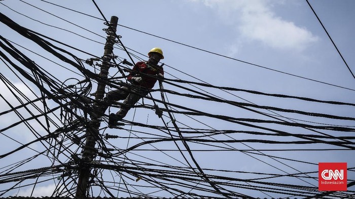 Petugas mengecek kabel listrik di kawsan Kebon Jeruk, Jakarta, 9 Januari 2019. Semrawutnya kabel tersebut dapat menyebakan korsleting. (CNN Indonesia/ Hesti Rika)