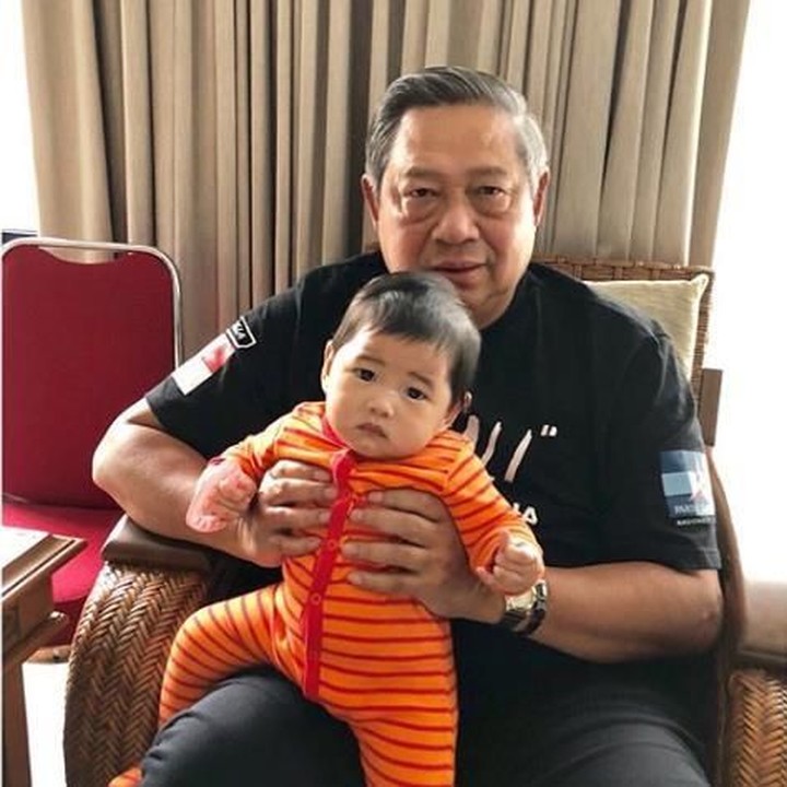 <p>Dedek Gaia sadar kamera nih. Kalau menurut Memo, saat di rumah, Pepo merupakan sosok yang sangat menyayangi cucunya. Jadi sering menghabiskan waktu untuk menggendong mereka. (Foto: Instagram @aniyudhoyono)</p>