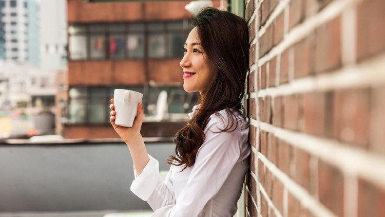 Young business woman having a break drinking an hot coffee on the rooftop of his office building in downtown Seoul, South Korea.