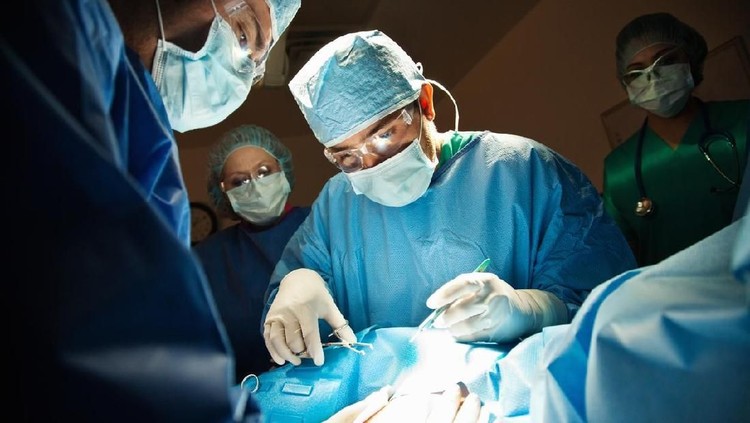 Surgeons performing C-Section in operating room.