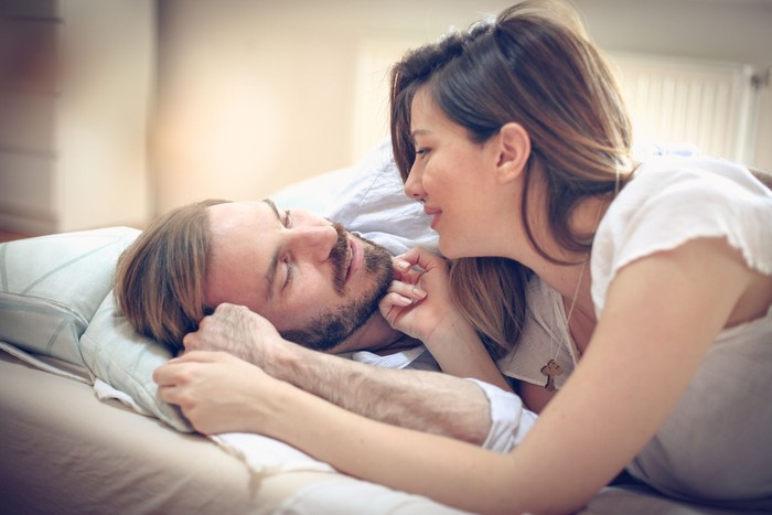 Loving couple relaxing and sleeping in bed, top view