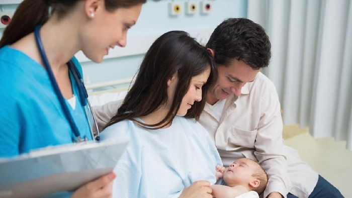 In the Hospital Mother Hold Newborn Baby, Supportive Father Lovingly Hugging Baby and Wife. Happy Family in the Modern Delivery Ward.