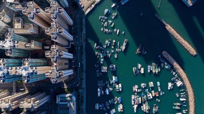 This aerial photo taken on October 29, 2018 shows boats moored at a typhoon shelter next to residential buildings in Hong Kong. (Photo by Dale DE LA REY / AFP)