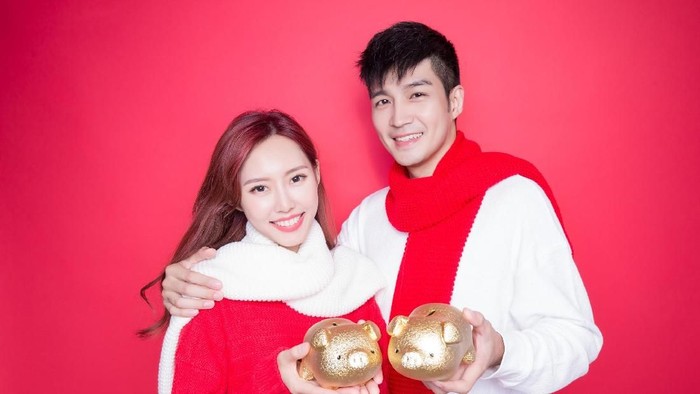 couple take piggy bank with chinese new year on red background