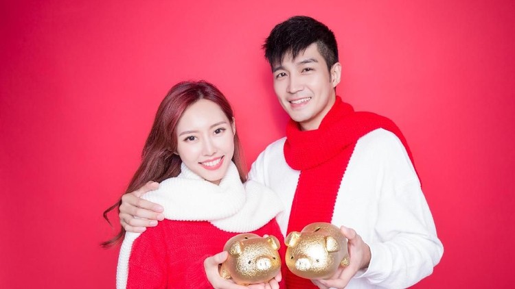 couple take piggy bank with chinese new year on red background