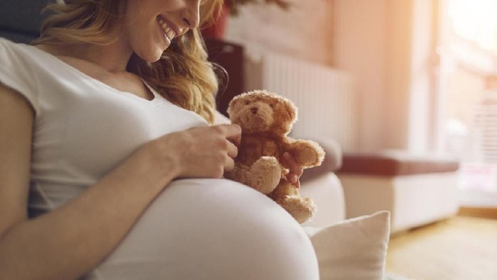 pregnancy, healthy food and people concept - happy pregnant woman eating vegetable salad for breakfast at home