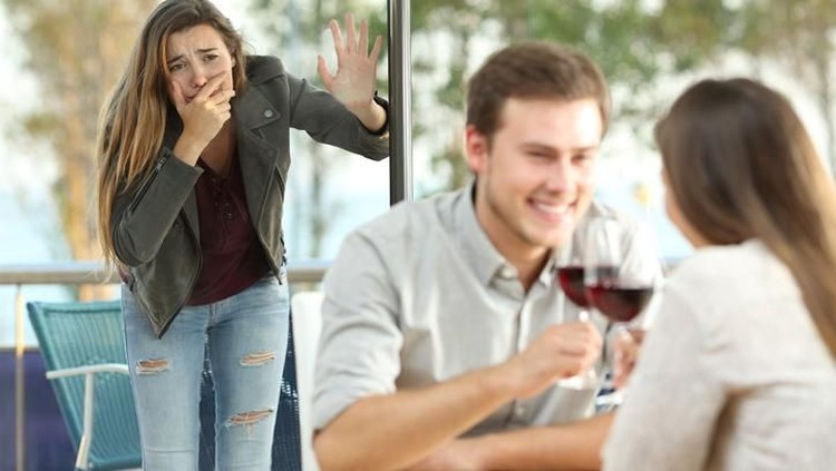 ilustrasi selingkuh Unfaithful young man in a cafe. He is embracing his girlfriend and making call gesture to another woman behind her back.