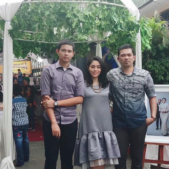 <p>Kompak memakai busana berwarna abu-abu bersama suami dan putra sulungnya, Titan Attariq di sebuah acara. (Foto: Instagram @saphira_indah)</p>