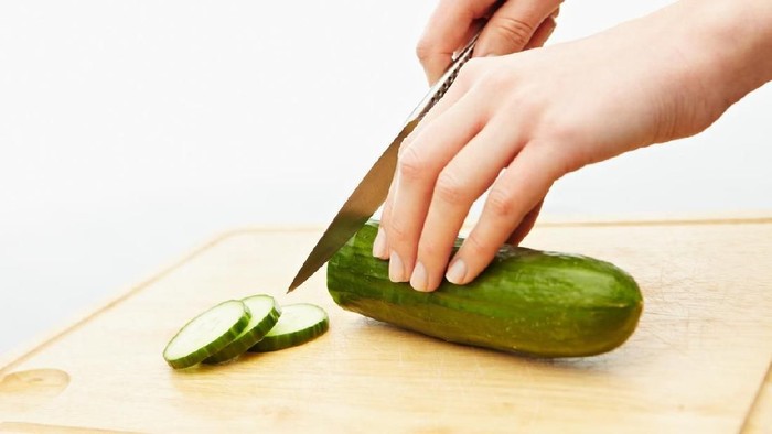 Cutting cucumber on a chopping board