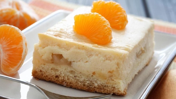 Close-up image of a piece cheese cake with mandarins.