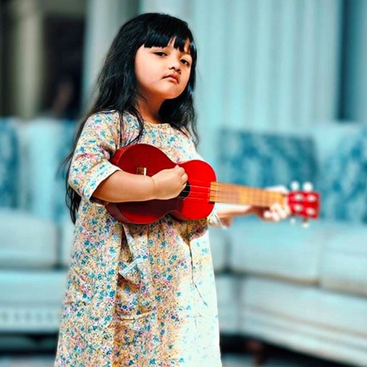 <p>Gayanya yang ini <em>cool</em> banget. Bawa gitar biar jadi musisi kayak Ayah Anang ya, Acio. (Foto: Instagram @queenarsy)</p>