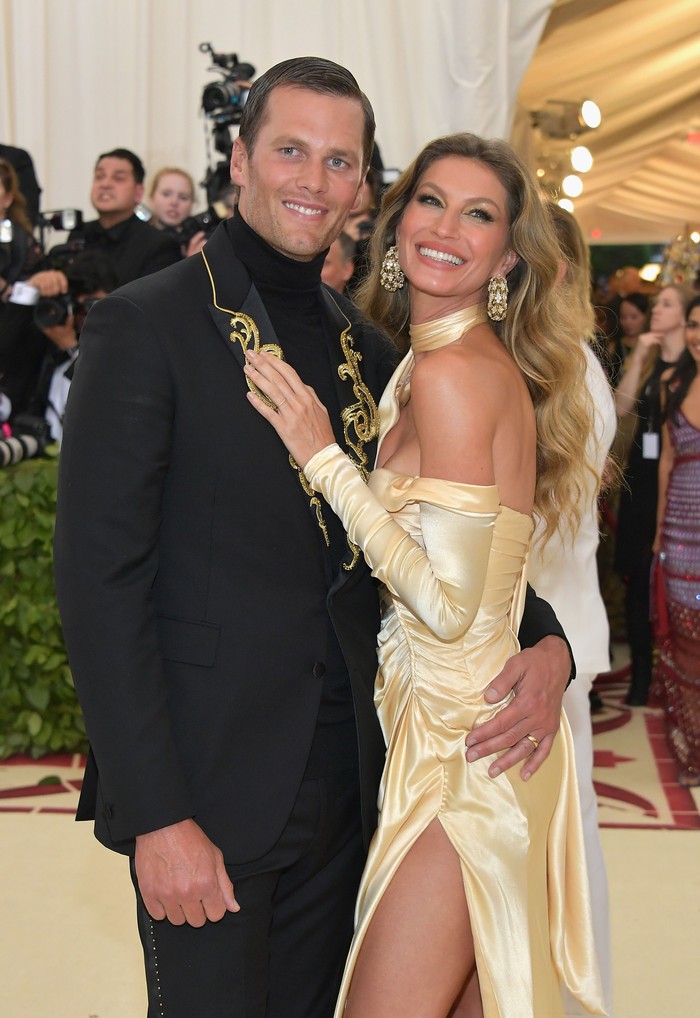 Nuansa retro terlihat pada gaya Tom dan Gisele di Met Gala 2018. Gisele dalam balutan gaun Versace ala era '90an dan Tom memakai setelan aksen bordir.Foto: Getty Images