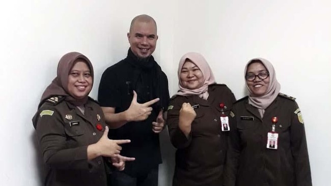 Sebuah foto beredar memperlihatkan Ahmad Dhani berpose dengan tiga jaksa perempuan. Satu dari mereka bergaya dengan mengacungkan dua jari ala 02.