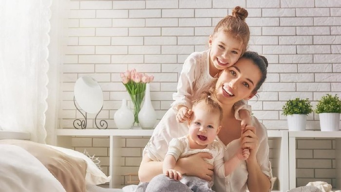 Two girls, sisters, friends, dance, play and jump on the bed in pretty outfits