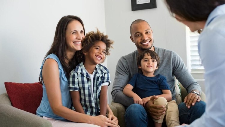 Multi-ethnic family meets with financial advisor, home consultant, insurance agent, or realtor.  African, Latin descent. Young couple, child, male agent.
