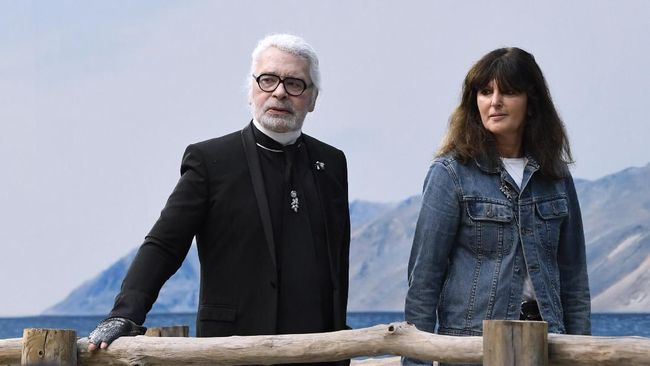 German fashion designer of Chanel, Karl Lagerfeld (L), flanked by French fashion studio director of Chanel Virginie Viard (R), acknowledges the audience at the end of the Chanel Spring-Summer 2019 Ready-to-Wear collection fashion show in Paris, on October 2, 2018. (Photo by Bertrand GUAY / AFP)