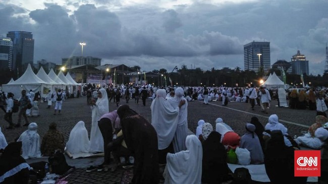 Aparat keamanan dan panitia memeriksa tas para peserta Malam Munajat 212 yang ingin masuk ke lokasi acara di Monas. Korek api jadi barang yang dilarang dibawa.