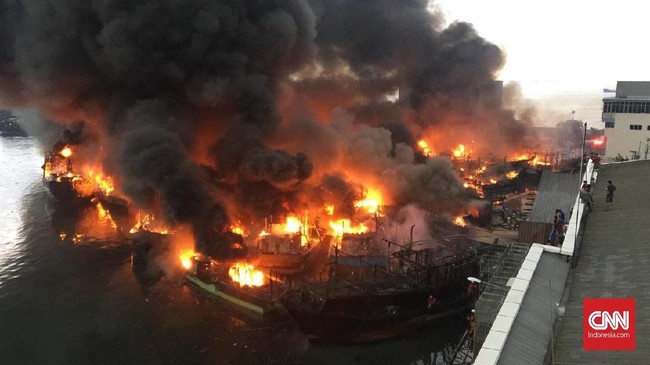 Kebakaran melanda Dermaga Muara Baru, Jakarta Utara pada Sabtu (23/2) sore. Sejumlah kapal nelayan yang terparkir di dermaga turut dilalap si jago merah.