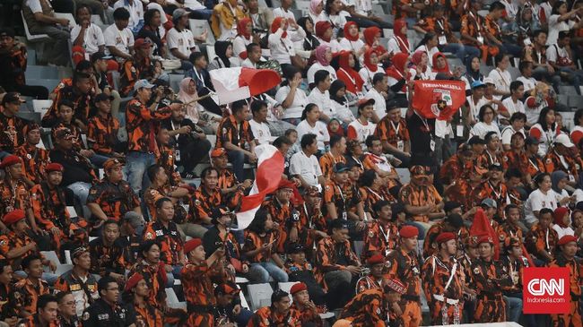 Pakai Loreng Oranye, Jokowi Hadir di Acara Pemuda Pancasila Kedatangan Jokowi disambut Bamsoet dan diiringi teriakan meriah dari anggota Pemuda Pancasila.
