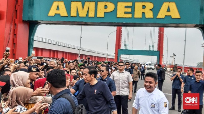 Presiden Joko Widodo menyapa langsung masyarakat yang berada di sekitar Jembatan Ampera di sela kunjungannya ke Palembang, Sumatera Selatan, pada Sabtu (9/3).