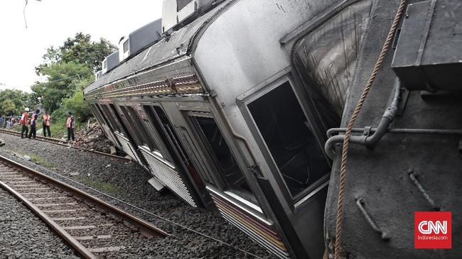 Kereta Rel Listrik (KRL) anjlok hingga menutup perlintasan. Masyarakat harus mencari jalur alternatif jika ingin melintas.