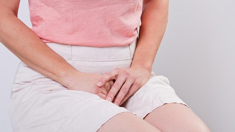 Young woman having painful stomachache with hands holding pressing her crotch lower abdomen. Medical or gynecological problems, healthcare concept