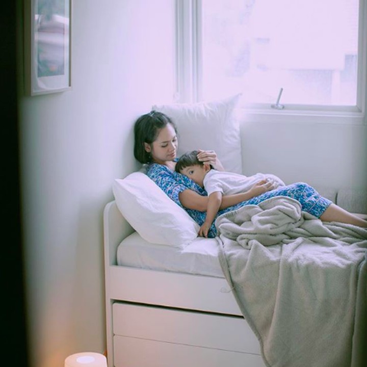 <p>Sofa putih dengan ukuran besar membuat sudut ruangan terlihat lebih menarik. Pemilihan cat tembok putih dengan alas bermotif tribal, menjadikan sudut tersebut terlihat sangat nyaman. (Foto: Instagram @andienaisyah)</p>