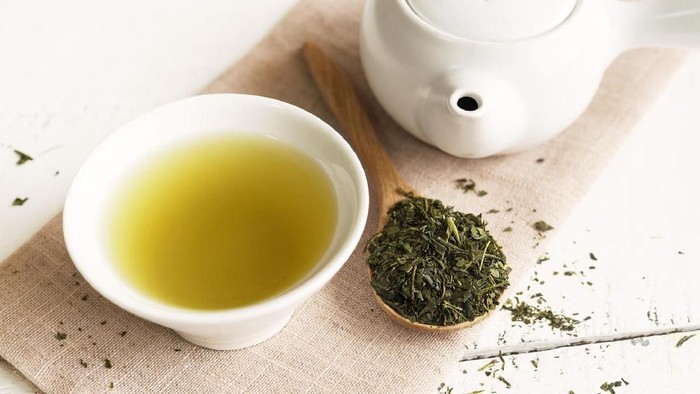 cup of herbal tea with chamomile flowers on a wooden table