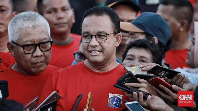 Gubernur DKI Jakarta Anies Baswedan dibawakan kue dan tumpeng oleh sekelompok orang saat berada di Jakarta International Stadium.