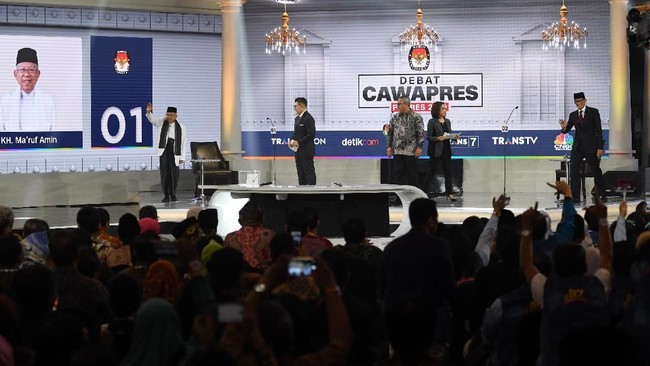 Para pendukung Prabowo-Sandi memenuhi ruangan dengan baju biru yang dibalut jaket jin. Sementara massa Jokowi-Ma'ruf serba putih