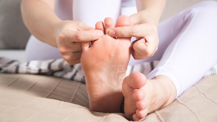 Woman's leg hurts, pain in the foot, massage of female feet at home