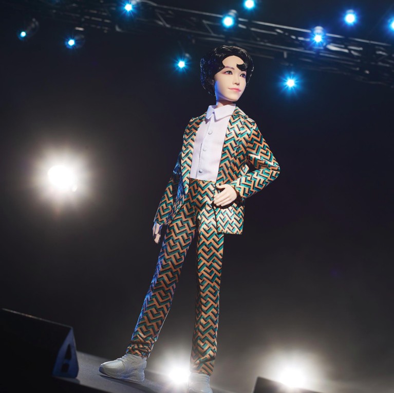 Kalau action figure J-Hope BTS ini dibuat lebih elegan dengan paduan warna hijau-hitam-emas pada kemeja dan celananya.